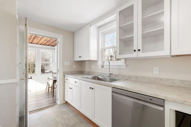 kitchen with a healthy amount of sunlight, sink, stainless steel dishwasher, and white cabinets