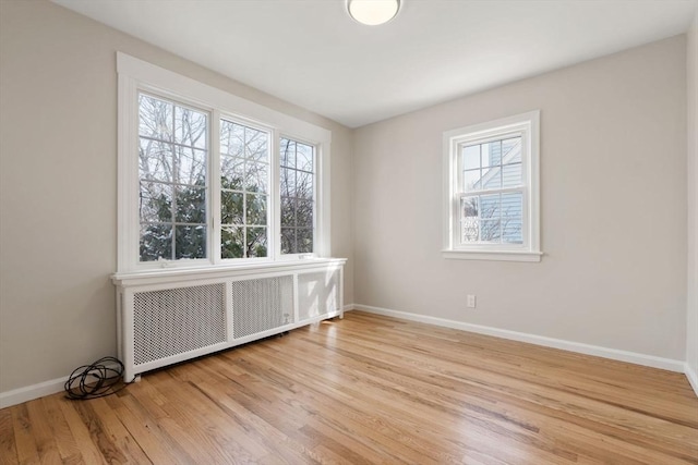 empty room featuring radiator and light wood-type flooring