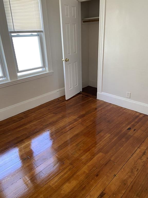 unfurnished bedroom featuring dark wood-type flooring and a closet