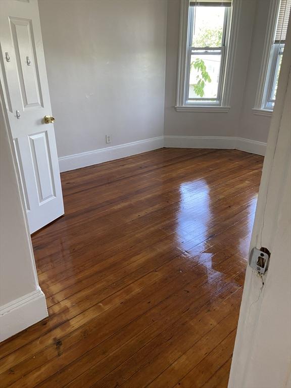 spare room featuring dark wood-type flooring