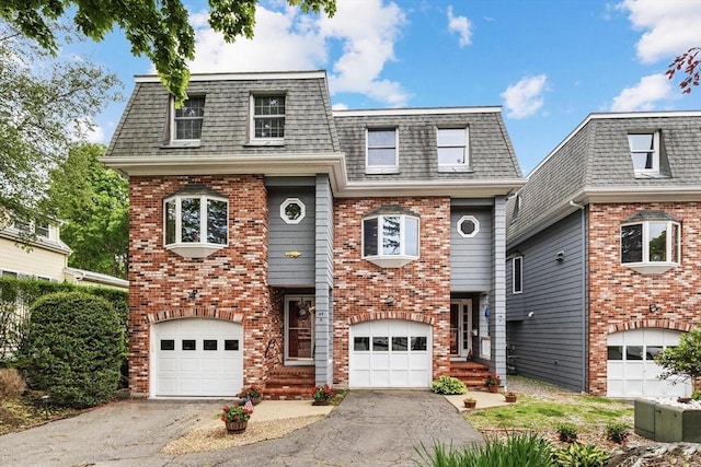 64 Prospect St Unit B, Marblehead, MA 01945 - view of front of property with driveway, mansard roof, brick siding, and roof with shingles