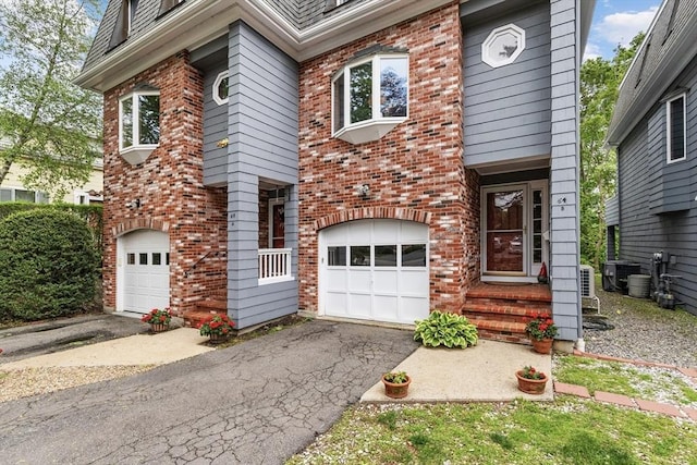64 Prospect St Unit B, Marblehead, MA 01945 - view of front of home featuring brick siding, a garage, and asphalt driveway