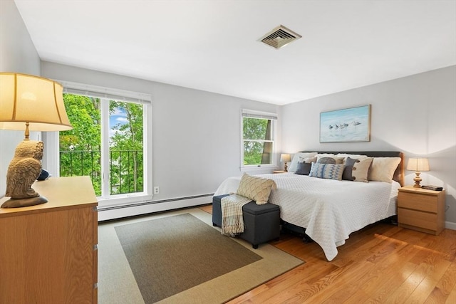64 Prospect St Unit B, Marblehead, MA 01945 - bedroom with a baseboard radiator, multiple windows, and light wood-style floors