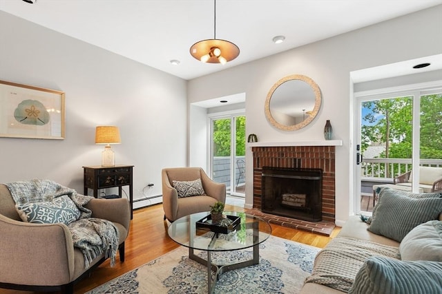 64 Prospect St Unit B, Marblehead, MA 01945 - living room featuring a baseboard heating unit, a brick fireplace, and wood finished floors