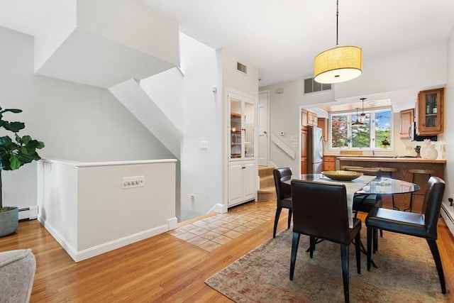 64 Prospect St Unit B, Marblehead, MA 01945 - dining room featuring a baseboard heating unit, light wood finished floors, and baseboards