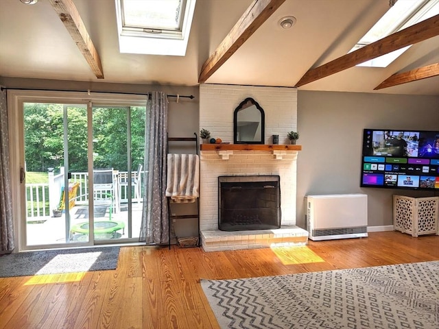 38 Pearson Dr, Newbury, MA 01922 - unfurnished living room featuring a skylight, wood finished floors, and a brick fireplace