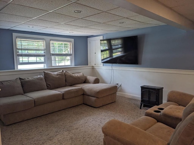 38 Pearson Dr, Newbury, MA 01922 - carpeted living area featuring a wainscoted wall, a wood stove, and a paneled ceiling