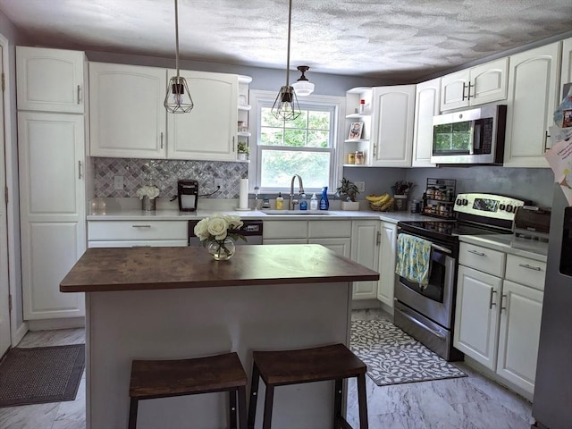 38 Pearson Dr, Newbury, MA 01922 - kitchen featuring appliances with stainless steel finishes, open shelves, light marble finish flooring, wood counters, and white cabinetry