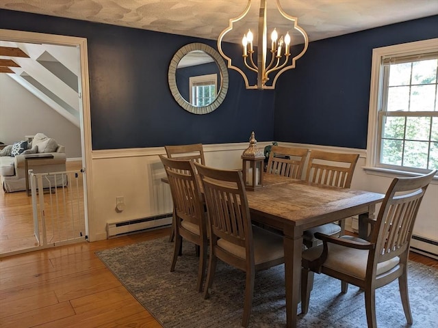 38 Pearson Dr, Newbury, MA 01922 - dining area featuring wood finished floors, a wainscoted wall, a chandelier, and a baseboard heating unit