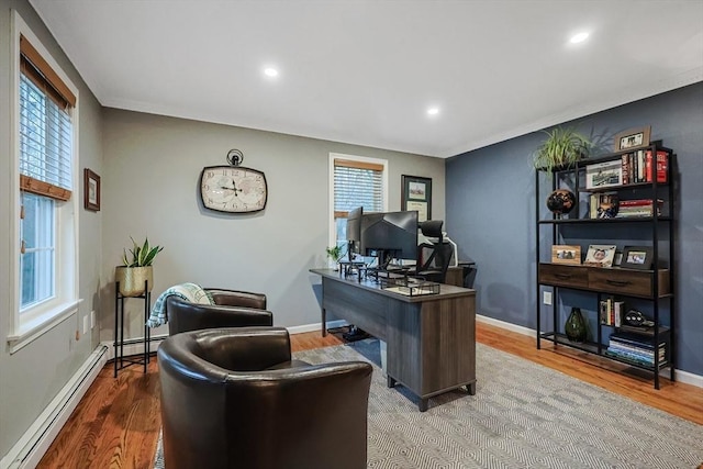 office area with a baseboard radiator, wood-type flooring, and a wealth of natural light