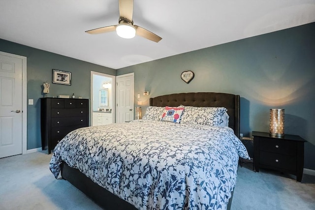 bedroom with light carpet, ensuite bath, and ceiling fan