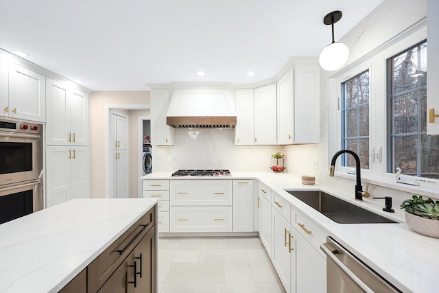 kitchen featuring decorative light fixtures, sink, white cabinets, custom exhaust hood, and stainless steel appliances