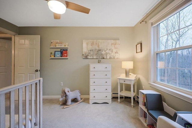 bedroom with carpet floors, a nursery area, and ceiling fan