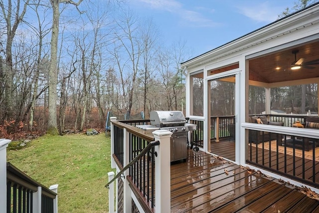 wooden terrace featuring area for grilling, a sunroom, a yard, and ceiling fan