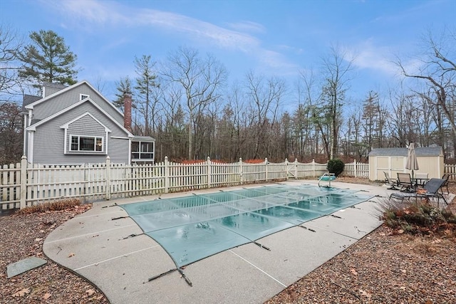 view of pool featuring a patio and a shed