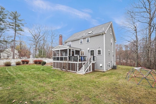 rear view of property featuring a sunroom and a yard