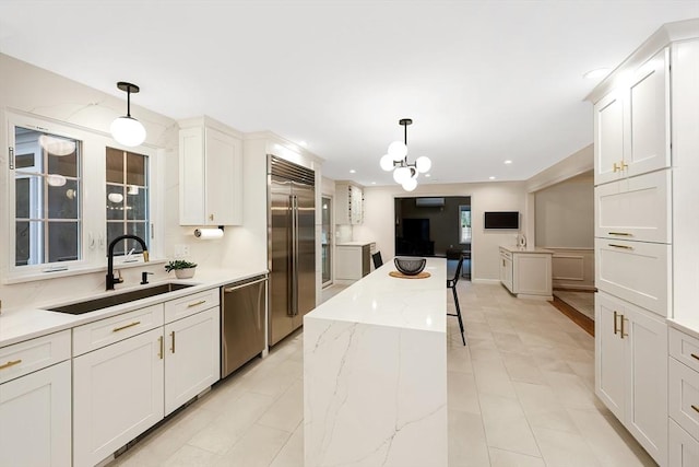 kitchen featuring sink, decorative light fixtures, stainless steel appliances, and a center island