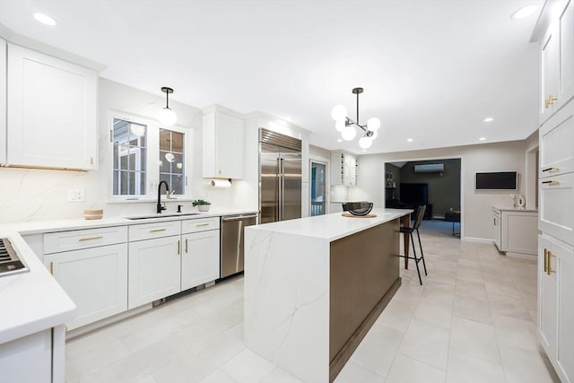 kitchen with white cabinetry, appliances with stainless steel finishes, decorative light fixtures, and sink