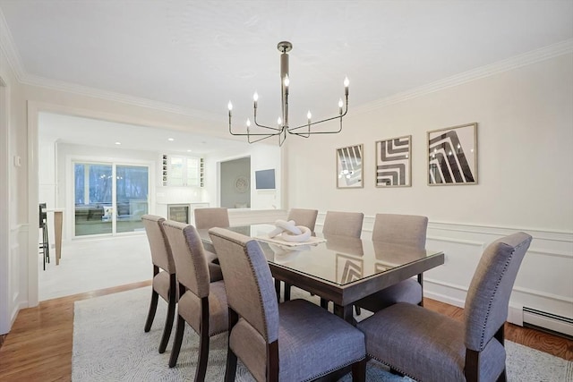 dining area featuring ornamental molding, an inviting chandelier, light hardwood / wood-style floors, and a baseboard radiator