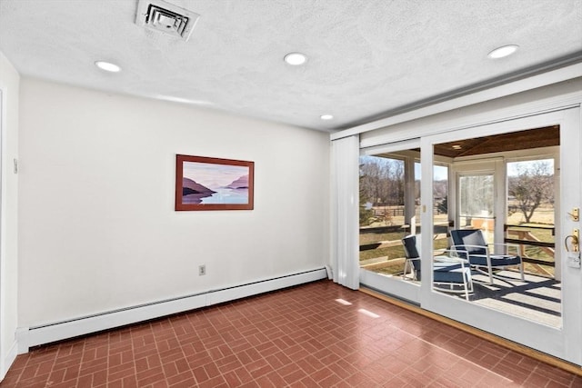 unfurnished room with a baseboard radiator and a textured ceiling