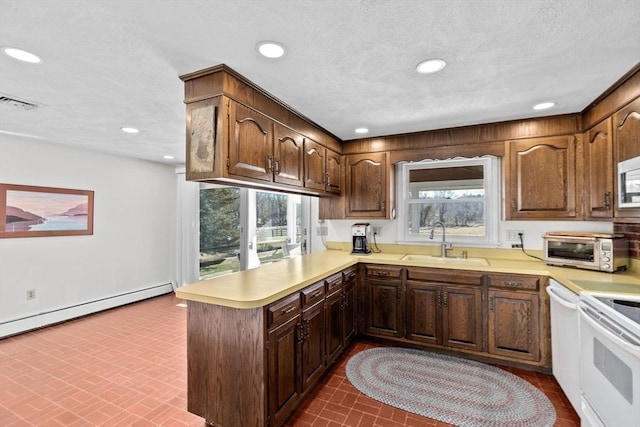 kitchen with sink, white appliances, baseboard heating, kitchen peninsula, and a textured ceiling