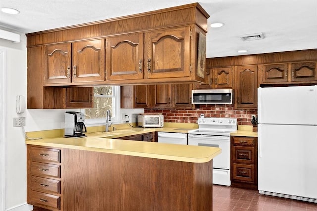 kitchen featuring sink, white appliances, and kitchen peninsula