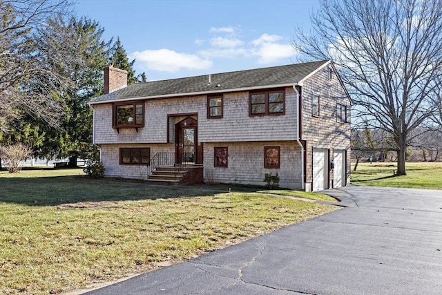 raised ranch with a garage and a front lawn