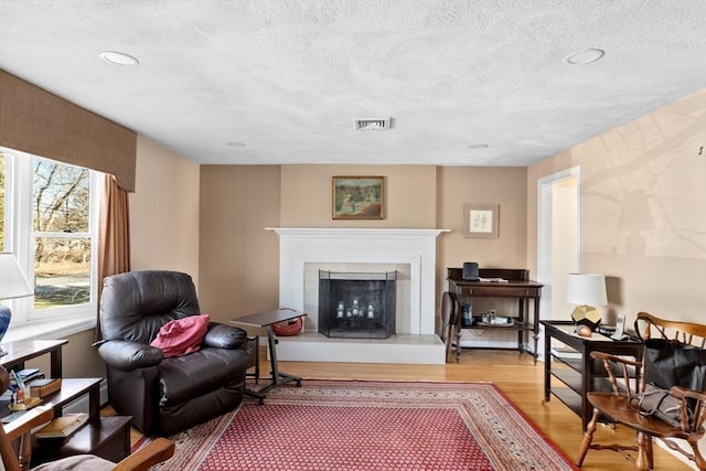 living area with a textured ceiling and light wood-type flooring