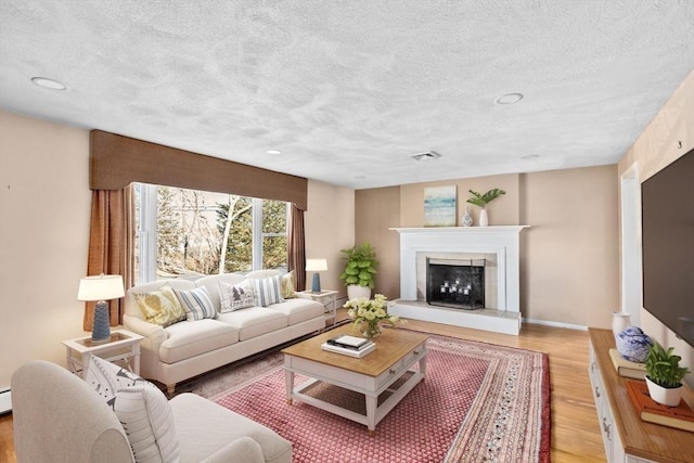 living room with light hardwood / wood-style flooring and a textured ceiling