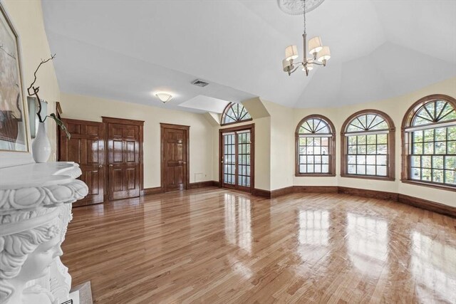 72 Charlemont St, Newton, MA 02461 - unfurnished living room featuring a chandelier, light wood-type flooring, vaulted ceiling, and baseboards