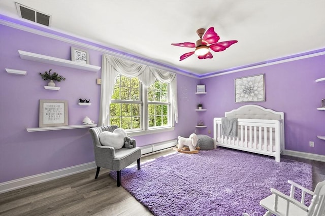 14 Weld St, Westborough, MA 01581 - bedroom with a baseboard heating unit, wood finished floors, a crib, baseboards, and crown molding