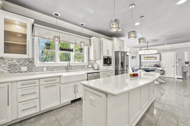 14 Weld St, Westborough, MA 01581 - kitchen featuring stainless steel appliances, crown molding, light marble finish flooring, a kitchen island, and white cabinetry