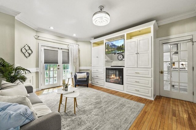 14 Weld St, Westborough, MA 01581 - living area featuring crown molding, french doors, light wood-style flooring, recessed lighting, and a glass covered fireplace