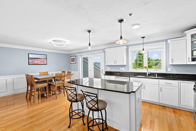 43 N Main St Unit B, Berkley, MA 02779 - kitchen featuring white cabinets, a kitchen breakfast bar, dishwashing machine, ornamental molding, and light wood-style flooring