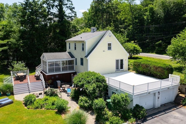 89 W Elm St, Pembroke, MA 02359 - rear view of house with a sunroom, a wooden deck, and a chimney