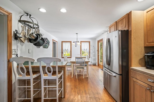89 W Elm St, Pembroke, MA 02359 - kitchen featuring freestanding refrigerator, light wood-style floors, recessed lighting, brown cabinets, and a kitchen bar