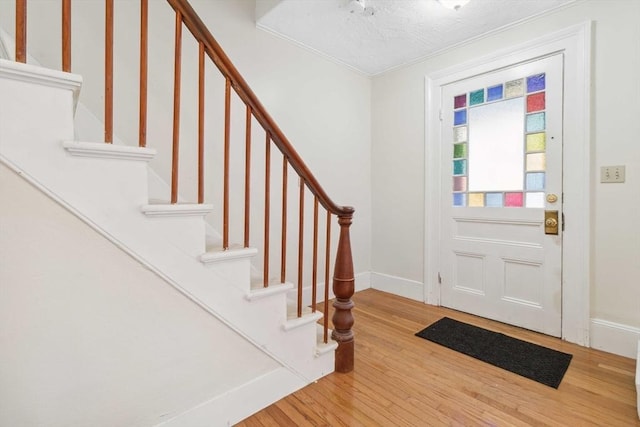 entrance foyer with a textured ceiling and light hardwood / wood-style floors