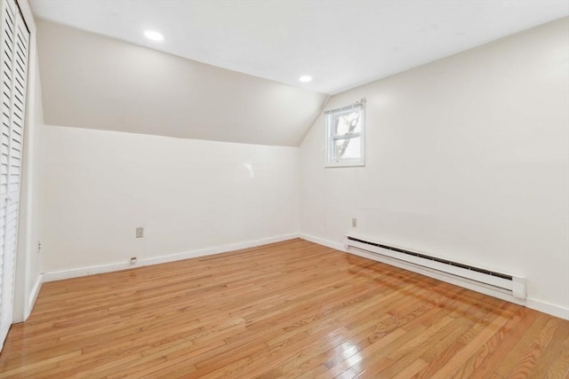 bonus room with vaulted ceiling, light hardwood / wood-style flooring, and a baseboard heating unit