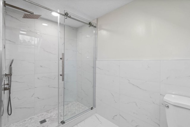 bathroom with toilet, an enclosed shower, and tile walls