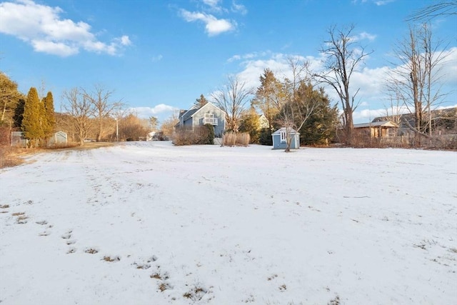 yard covered in snow featuring a storage unit