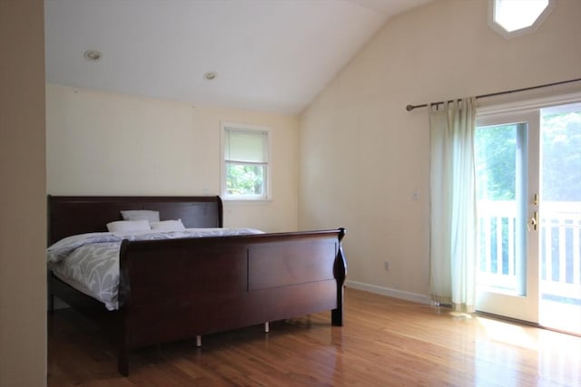 bedroom with lofted ceiling, access to exterior, and light hardwood / wood-style floors