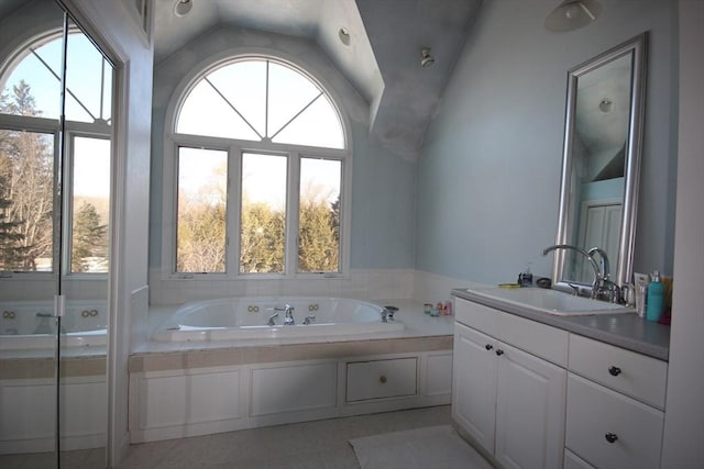 bathroom with tile patterned flooring, vanity, plenty of natural light, and vaulted ceiling