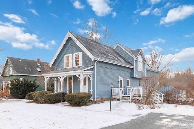 snow covered property with a porch