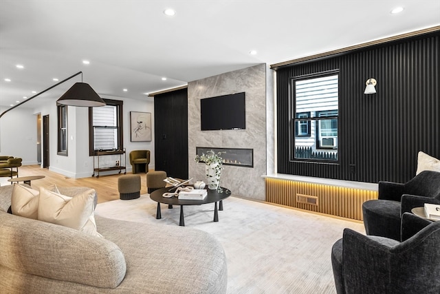 living room featuring light wood-type flooring and a fireplace