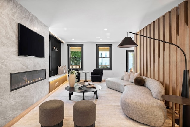 living room featuring a tiled fireplace and wood-type flooring