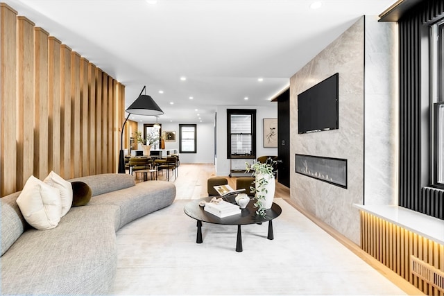 living room with light wood-type flooring and a large fireplace