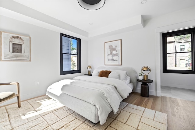 bedroom featuring multiple windows and light wood-type flooring