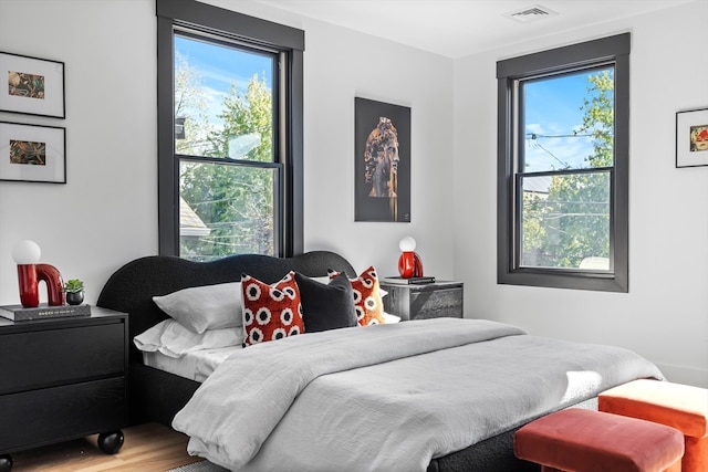 bedroom featuring hardwood / wood-style floors and multiple windows