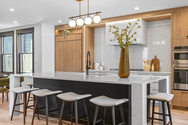 kitchen with sink, backsplash, and light hardwood / wood-style flooring