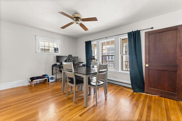 dining area featuring ceiling fan, light hardwood / wood-style flooring, and a baseboard heating unit